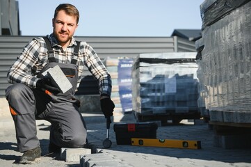 Professional paver worker lays paving stones in layers for pathway, Labor and industry concept