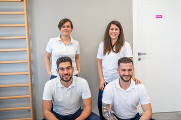Group of four young Caucasian physiotherapists smiling in their professional clinic