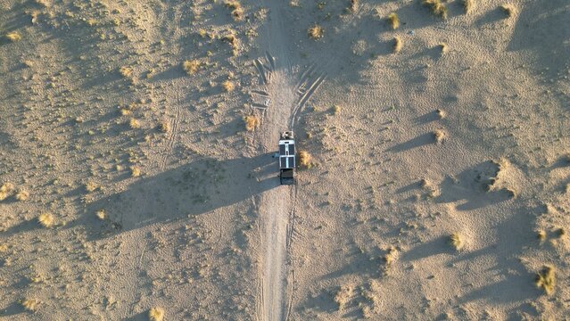 Drohnenaufnahme eines Expeditionsfahrzeugs auf einsamer Sandpiste in weiter Landschaft &ndash; Abenteuer, Freiheit, Minimalismus und Reisen abseits der Zivilisationfault