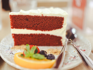 Delicious gourmet slice of fresh chocolate cheesecake topped with cream and red strawberry fruit on a white plate as a tasty sweet dessert snack