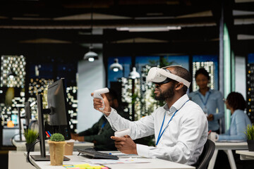 Black businessman using VR headset and gadgets to draft a project plan, engaged in forecasting projections and documenting risk assessment results. Solve tasks with virtual reality.