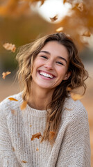 Joyful autumn portrait of a smiling woman in cozy sweater surrounded by falling leaves