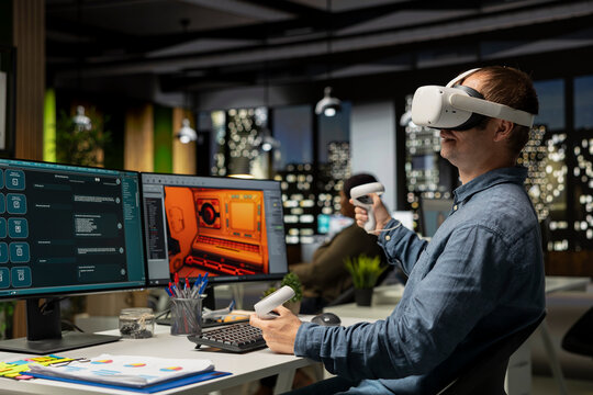 Male game developer using VR glasses and AI tech to design a spaceship for a video game, moving assets in 3D software for the spatial environment. Virtual development for the internet.