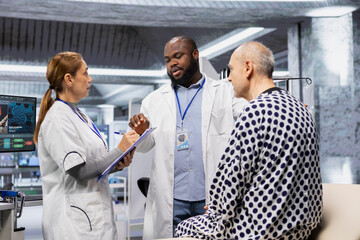 Two researchers testing a patient during a drug trial and recording side effects, monitoring dosage and studying allergic reactions. Biotechnology and clinical research for innovation.