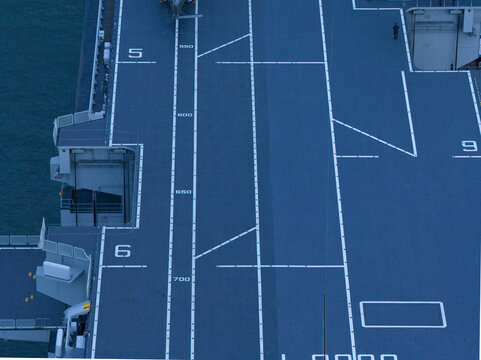 Aerial view of the flight deck of the LHD Trieste, a symphony of blue and white lines under the Italian sun, Trieste, Italy.