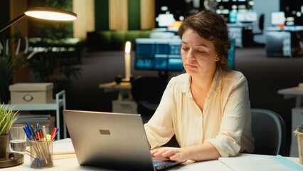 Discouraged woman creating plans and documenting objectives to share with executives during next morning meeting. Employee drained and in a mental haze doing overtime, pushing limits. Camera B.