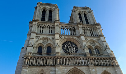 Notre Dame Cathedral facade in Paris with space for text and clear blue sky