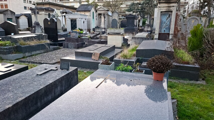 Cemetery in Passy Paris with tombstones and greenery in a quiet space during daylight