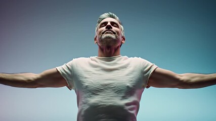 Man with arms outstretched in a moment of freedom and joy, looking up.