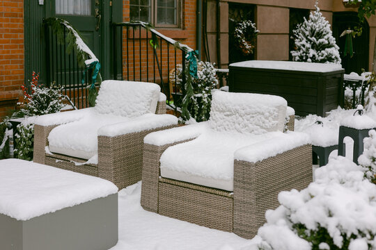 Snow covers outdoor furniture in a residential yard during winter months in a quiet neighborhood