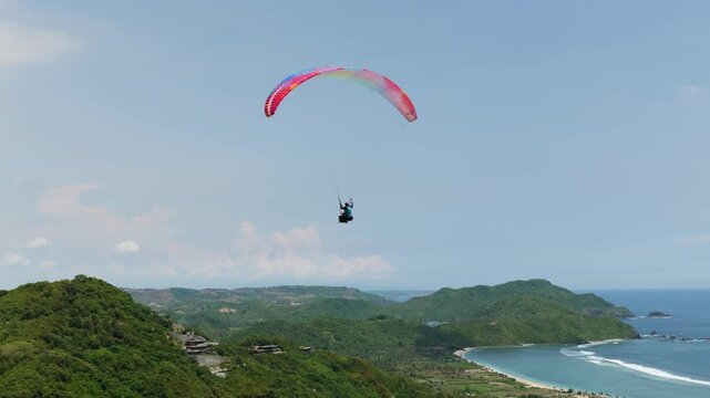 Lombok Indonesia 22 11 2025. Tourists paragliding with instructors above green landscapes and paradisiacal scenery on the island