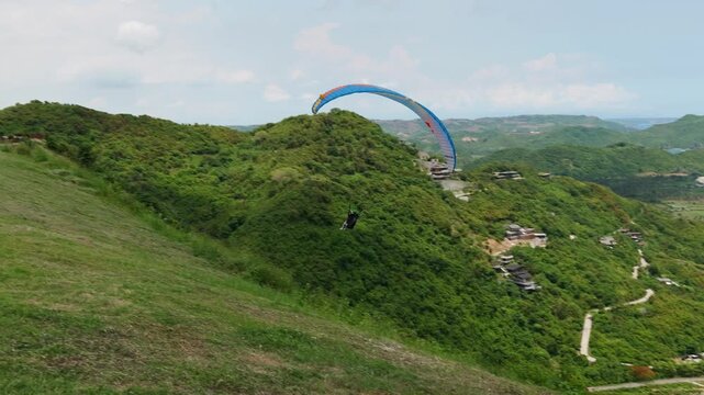 Lombok Indonesia 22 11 2025. Tourists paragliding with instructors above green landscapes and paradisiacal scenery on the island