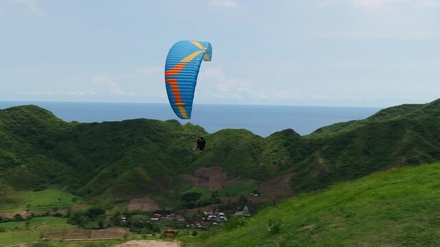 Lombok Indonesia 22 11 2025. Tourists paragliding with instructors above green landscapes and paradisiacal scenery on the island