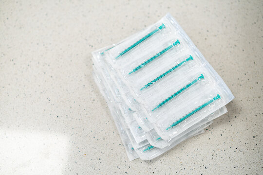 Disposable medical syringes in bulk. Many single use syringes prepared for healthcare, vaccination, or laboratory use.