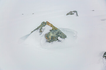 Snow Covered Rocks Rising From Quiet White Landscape in Whister, BC, Canada