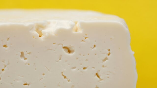 Close up view of fresh cheese on yellow background