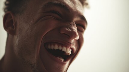 Close-up of a young man with a broad genuine smile expressing happiness and joy