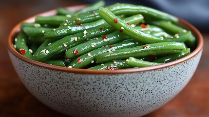 A Bowl of Glazed Green Beans Dusted with Sesame Seeds on a Rustic Wooden Table