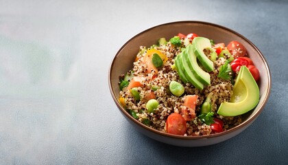 healthy quinoa salad with vegetables and avocado served in a bowl
