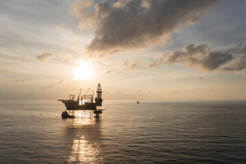Aerial view of offshore jack up rig in a shipyard during sunset for oil and gas exploration and production.