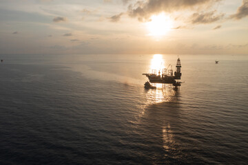 Aerial view of offshore jack up rig in a shipyard during sunset for oil and gas exploration and production.