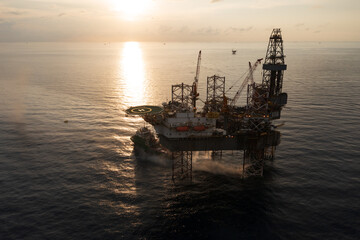 Aerial view of offshore jack up rig in a shipyard during sunset for oil and gas exploration and production.