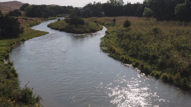 High view of the Dismal River in central Nebraska, showing the river&rsquo;s curving green edge, an island, and the nearby Sandhills