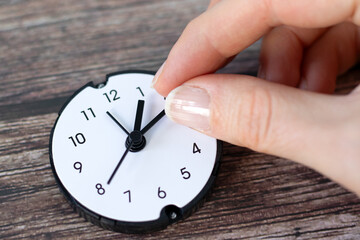 Hand holding clock arrow. Close-up. Time management, control, patience, reset, deadline and change concept.