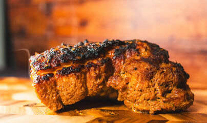 Whole pork joint freshly out of the oven, crispy fat, steaming hot on a wooden board. Juicy inside, ready to carve. Perfect for festive meals and gatherings.