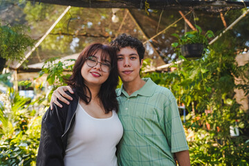 Happy young couple posing together in garden