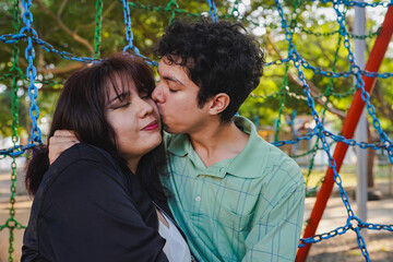Obraz premium Couple sharing a tender kiss in park playground