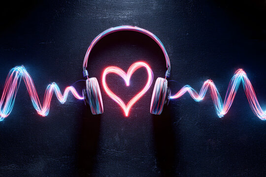 Headphones and sound waves create a heart shape with colorful lights in a dark setting during night