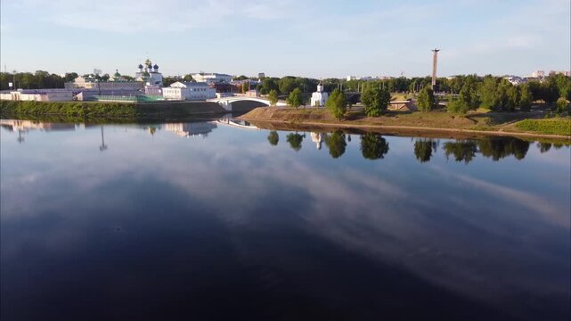 A drone flies over the Volga River in Tver and gains altitude, revealing views of a church, a cathedral, the Victory Obelisk, and the surrounding city.