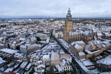 Medieval Hanseatic Dutch tower town Zutphen in the Netherlands covered in snow with historic heritage buildings and Walburgiskerk church rising above the cityscape