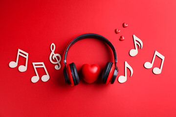 Headphones, heart figures and music notes on red background, flat lay © New Africa