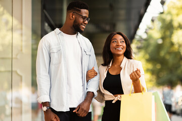 Portrait of successful African American couple spending time together after shopping in mall...