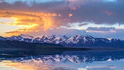 A breathtaking landscape mirroring snow-capped peaks in tranquil waters beneath a vibrant sunset sky with dramatic cloud formations