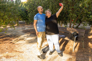 Couple taking selfie with mobile phone in park