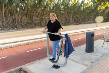 Woman exercising outdoors using park fitness equipment