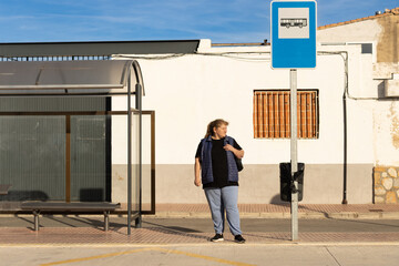 Woman waiting at bus stop for public transport