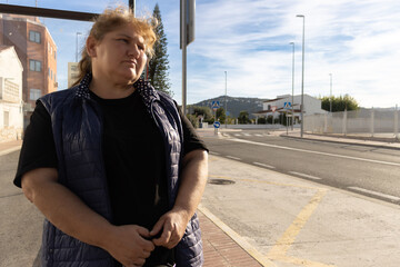 Woman waiting for bus contemplating urban street view