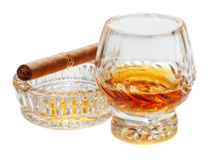 A glass of whiskey sits on a table next to a cigar
