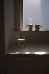 Quiet connection setting Two mugs on windowsill steam rising empty chairs side by side waiting warmth