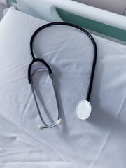 Stethoscope resting on empty hospital bed pillow