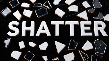 Broken Glass Shards Spelling "Shatter" on Black Background