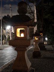 ロウソクの火が灯された石灯籠