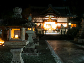 ロウソクの火が灯された石灯籠