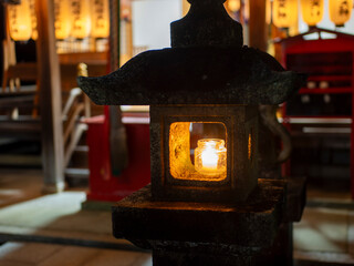 ロウソクの火が灯された石灯籠