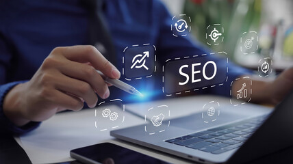 Businessman using laptop to analyze SEO (search engine optimization) for promoting website traffic...