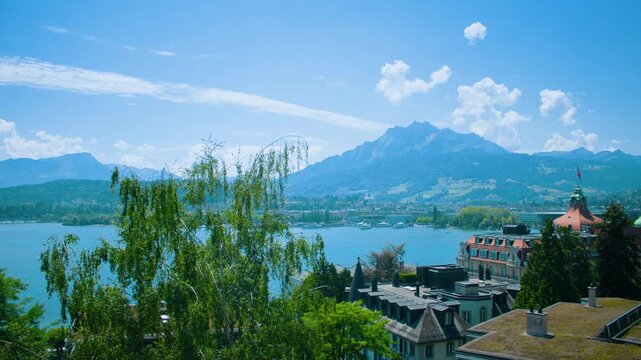Scenic view of Lake Lucerne with calm water, surrounding mountains, and lush greenery on a clear summer day.